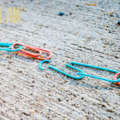 Colorful plastic chain links lie broken in the middle on a rough pavement, with the jzlaw logo in the top left and www.jzlaw.ca in the bottom right.