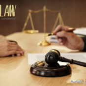 Gavel and scales of justice on a desk with two people signing a document; JZW Law logo visible.