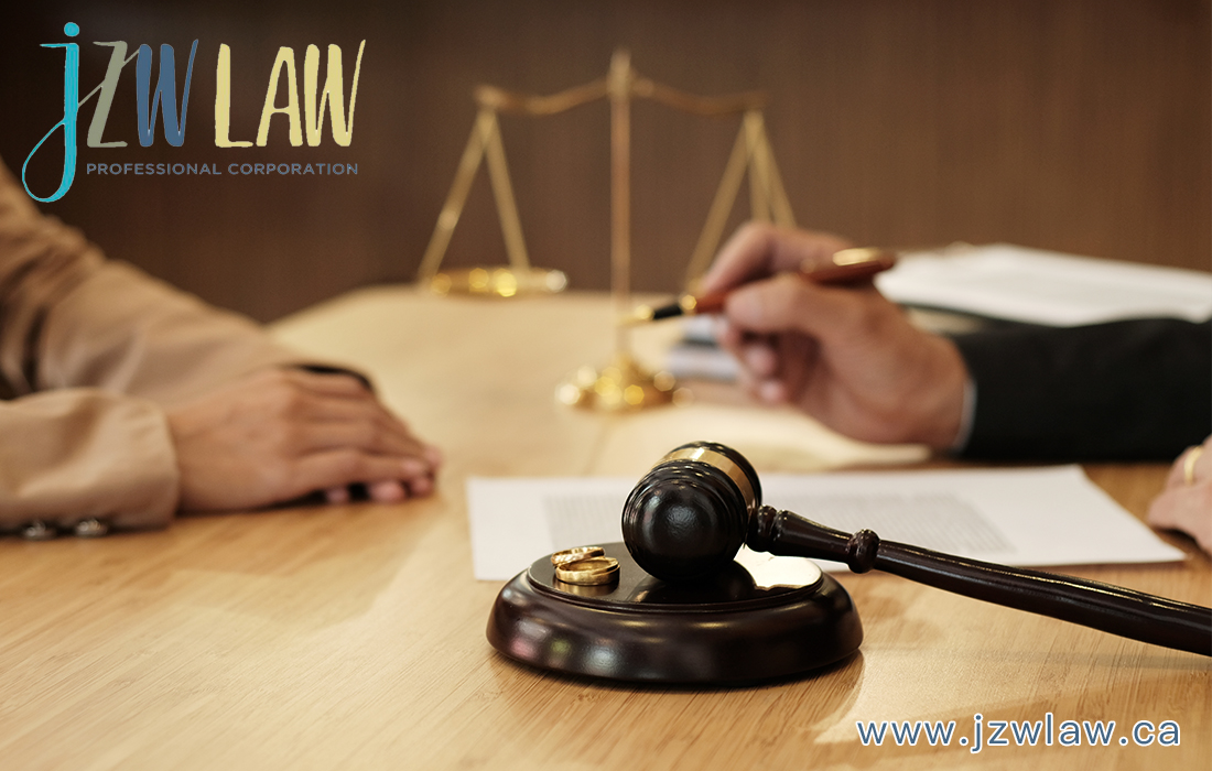 Gavel and scales of justice on a desk with two people signing a document; JZW Law logo visible.