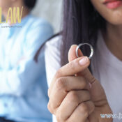 Close-up of a hand holding a silver ring, with a blurred person in the background and the jzwLAW professional corporation logo in the corner.