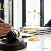 Logo for 'jzwLAW Professional Corporation' on a lawyer's desk beside scales of justice, a gavel, and stacked books.