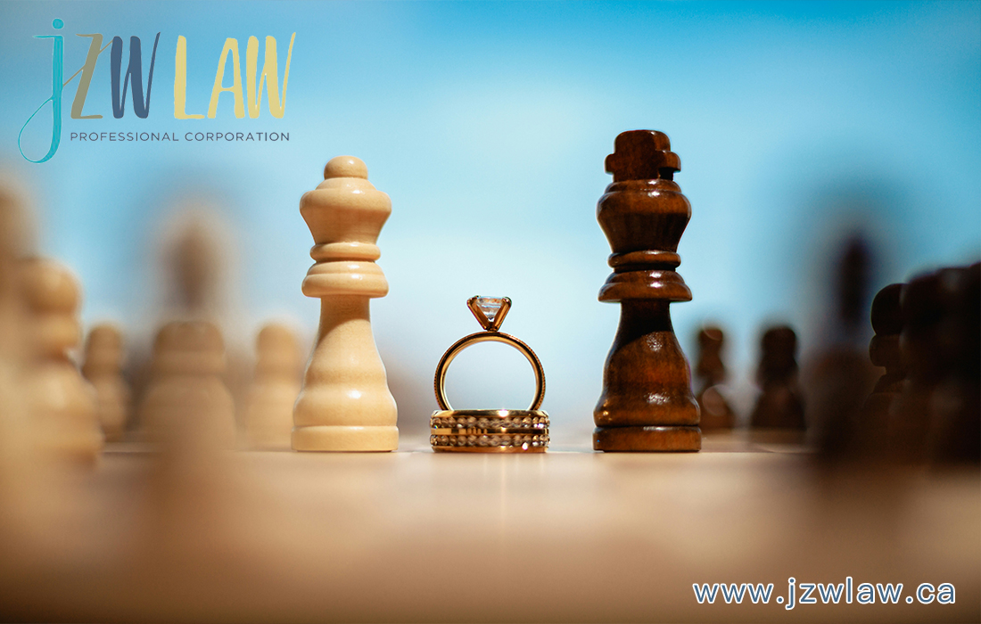 Engagement ring between white and dark chess kings on a board with a blurred law firm logo in the background