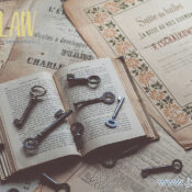 Open antique book with several old keys scattered on its pages amid aged papers and a JZ Law branding watermark.