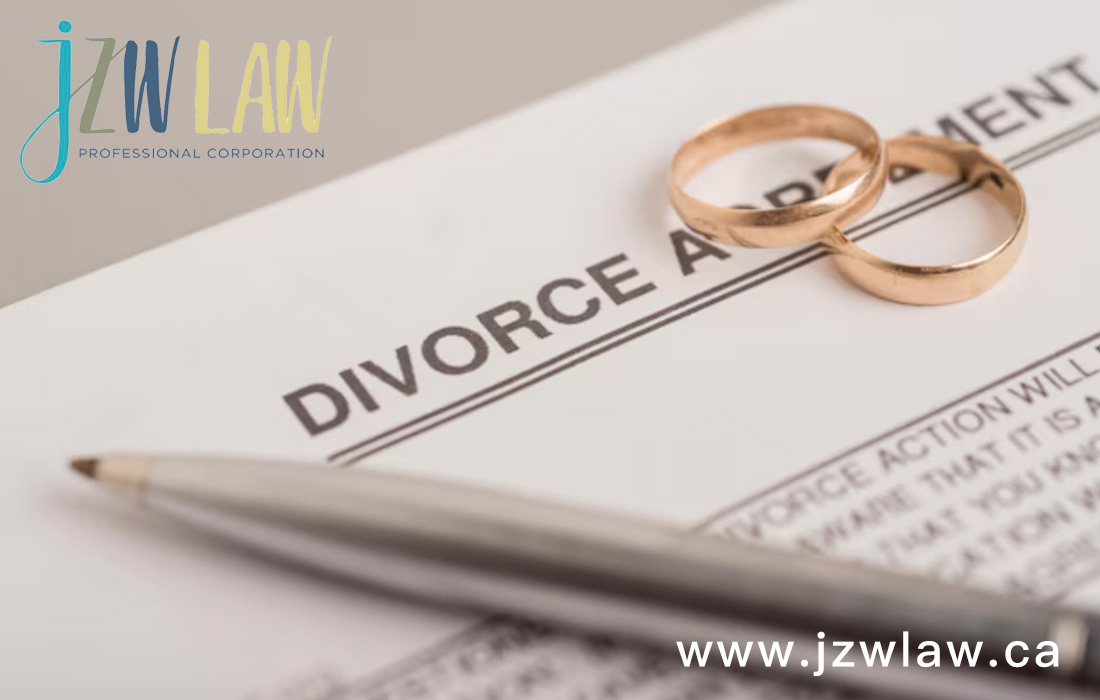 Divorce document with two gold wedding rings and a pen on top; law firm logo in the corner with the website www.jzwlaw.ca
