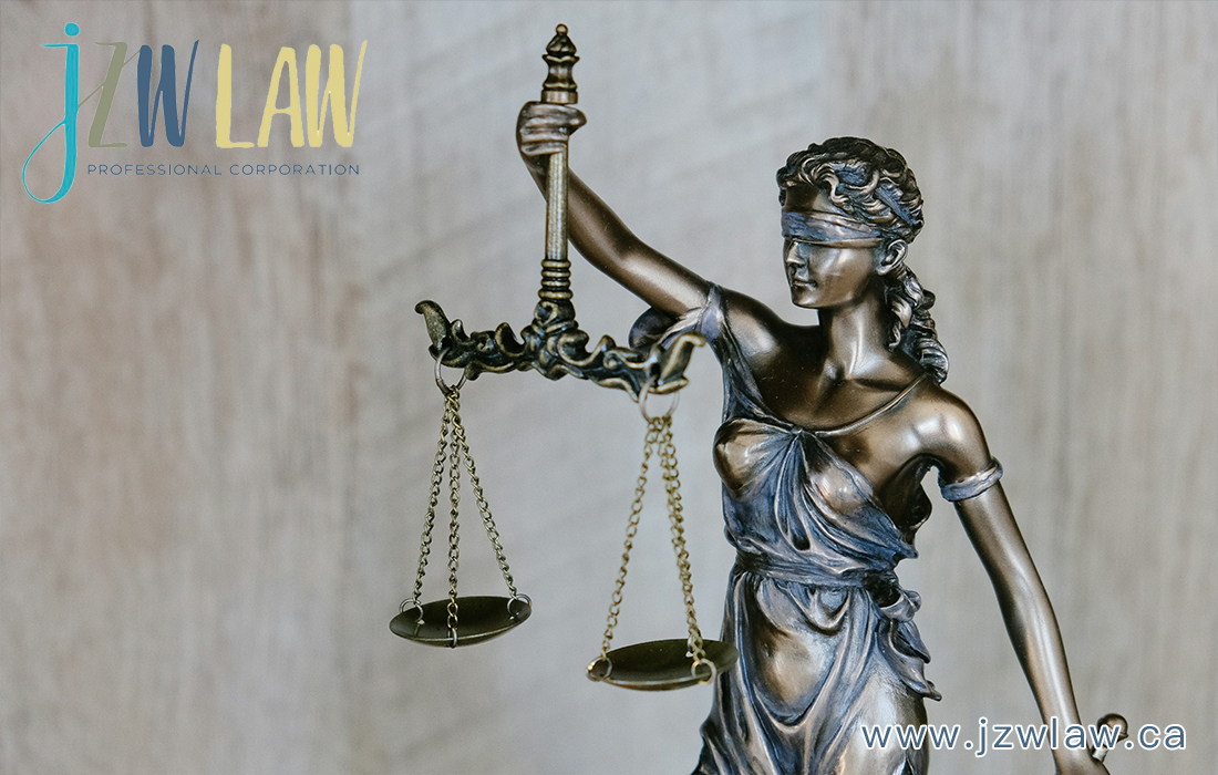 Statue of Lady Justice holding scales, with a law firm logo in the top left and the website at bottom right.