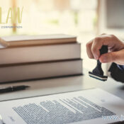 A hand stamping a contract at a desk with a stack of books; JZW Law logo top left and www.jzlaw.ca bottom right.